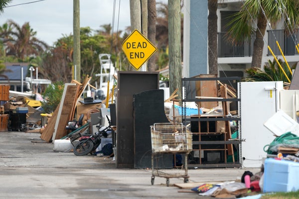 Debris left by Hurricane Helene is piled up in the street